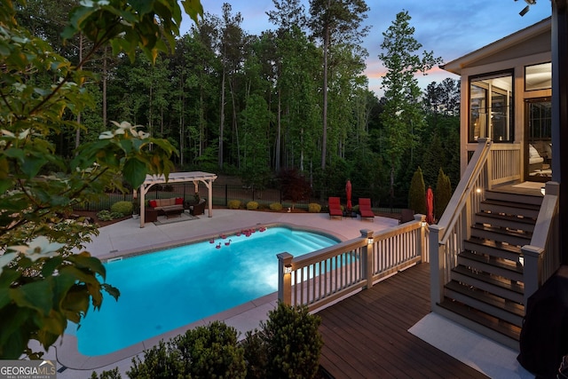 outdoor pool with a patio, an outdoor hangout area, fence, and a wooden deck