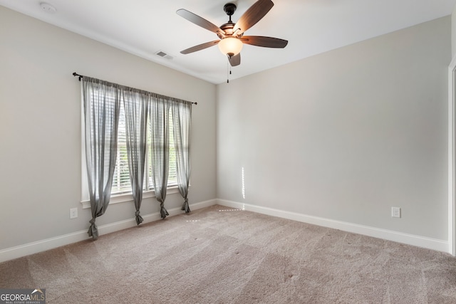 spare room featuring carpet flooring, a ceiling fan, and baseboards