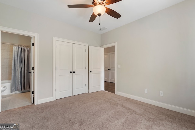 unfurnished bedroom featuring carpet flooring, baseboards, a closet, and ensuite bathroom