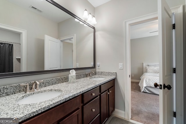 full bath with baseboards, double vanity, and ensuite bath