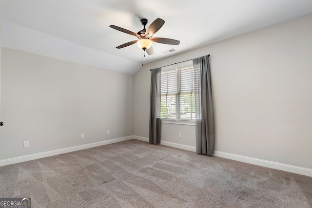 carpeted empty room with ceiling fan, baseboards, and vaulted ceiling