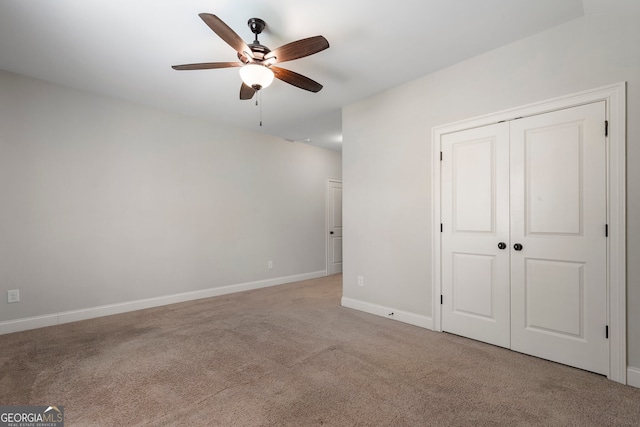 carpeted empty room featuring ceiling fan and baseboards
