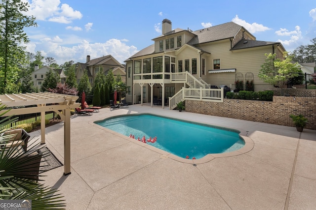 view of swimming pool featuring a sunroom, stairs, a patio area, and fence