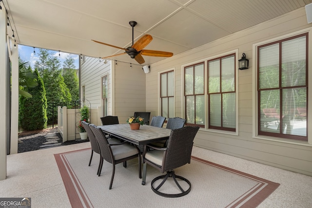 sunroom / solarium with ceiling fan and outdoor dining space