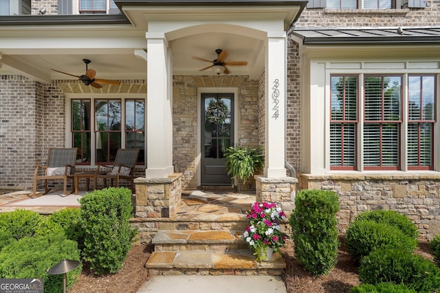 view of exterior entry with ceiling fan, a standing seam roof, stone siding, and metal roof