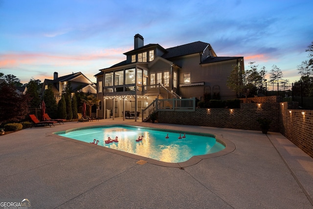 view of pool featuring a patio, stairs, fence, and a sunroom