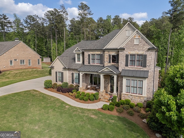 craftsman-style home with covered porch, a front yard, roof with shingles, and a standing seam roof