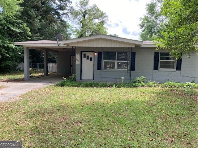 218 Lassiter Dr, Dublin, GA 31021 - ranch-style house with fence, driveway, a front yard, and a carport