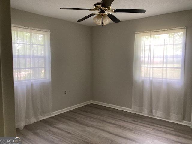 218 Lassiter Dr, Dublin, GA 31021 - empty room with baseboards, a ceiling fan, and wood finished floors
