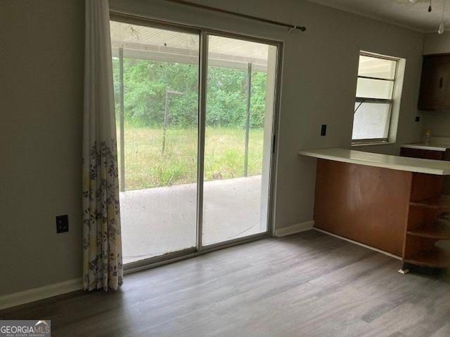 218 Lassiter Dr, Dublin, GA 31021 - unfurnished dining area with baseboards and wood finished floors