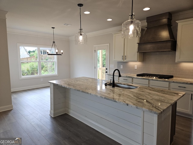 457 Banff Dr, Winder, GA 30680 - kitchen with premium range hood, a sink, stainless steel gas stovetop, a kitchen island with sink, and baseboards