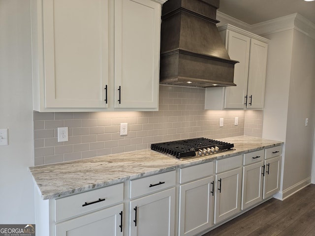 457 Banff Dr, Winder, GA 30680 - kitchen featuring custom range hood, stainless steel gas stovetop, dark wood-style floors, ornamental molding, and white cabinetry