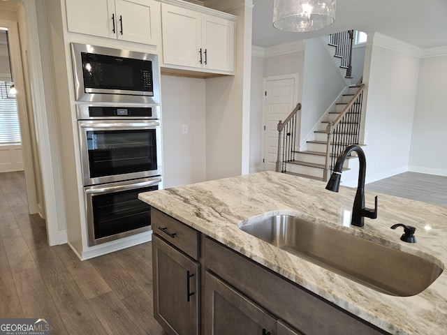 457 Banff Dr, Winder, GA 30680 - kitchen with a sink, crown molding, appliances with stainless steel finishes, dark wood-style floors, and light stone countertops