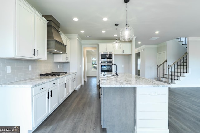 457 Banff Dr, Winder, GA 30680 - kitchen featuring appliances with stainless steel finishes, crown molding, wood finished floors, premium range hood, and recessed lighting