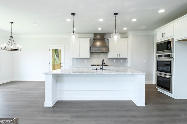 457 Banff Dr, Winder, GA 30680 - kitchen with custom range hood, appliances with stainless steel finishes, ornamental molding, a center island with sink, and decorative backsplash