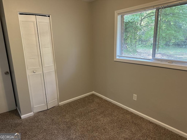 1685 Pheasant Dr, Jonesboro, GA 30238 - unfurnished bedroom featuring baseboards, a closet, and dark colored carpet