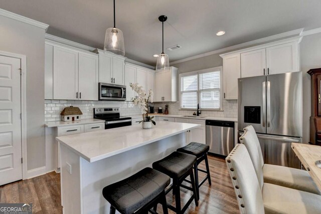 5299 Noble Village Way, Lilburn, GA 30047 - kitchen featuring crown molding, appliances with stainless steel finishes, a sink, visible vents, and dark wood-style floors