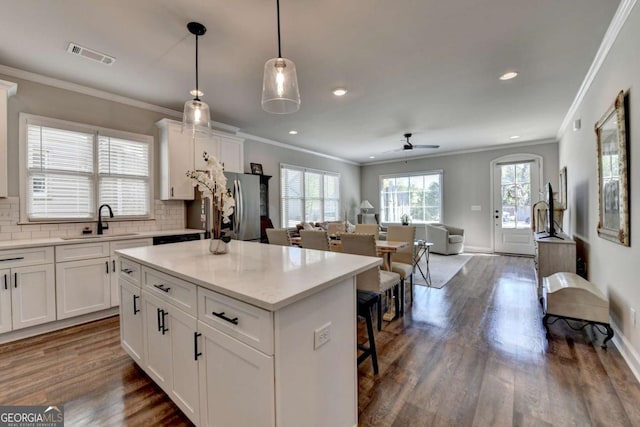 5299 Noble Village Way, Lilburn, GA 30047 - kitchen featuring visible vents, freestanding refrigerator, dark wood-type flooring, white cabinets, and a sink