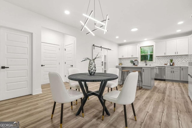 921 Cone Rd, Forest Park, GA 30297 - dining room featuring a barn door, light wood-style floors, and recessed lighting