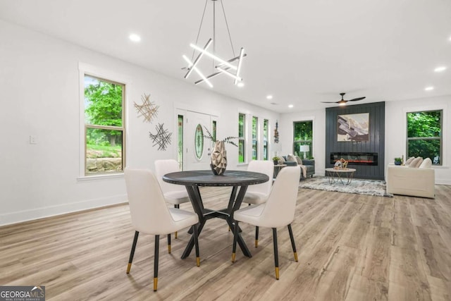 dining space with ceiling fan, light wood finished floors, a fireplace, recessed lighting, and baseboards