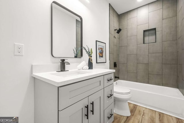 full bathroom with toilet, tub / shower combination, wood finished floors, and vanity