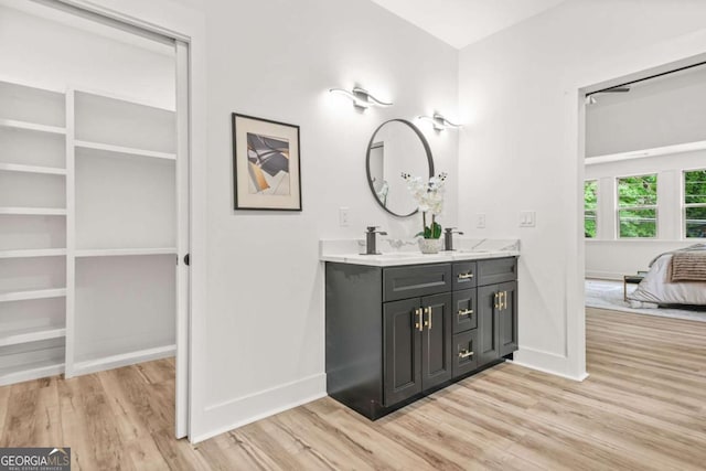 ensuite bathroom featuring baseboards, wood finished floors, and ensuite bathroom