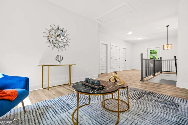 living room with recessed lighting, baseboards, wood finished floors, and attic access