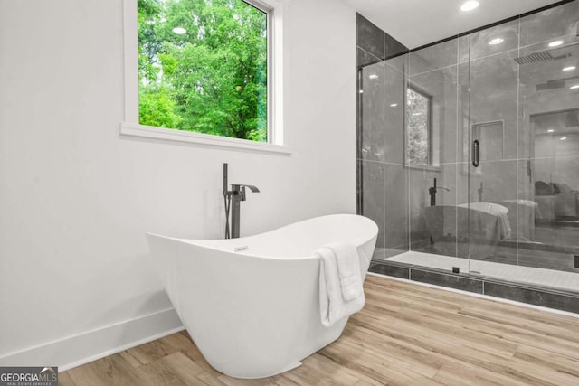 921 Cone Rd, Forest Park, GA 30297 - bathroom with a freestanding tub, a shower stall, and wood finished floors