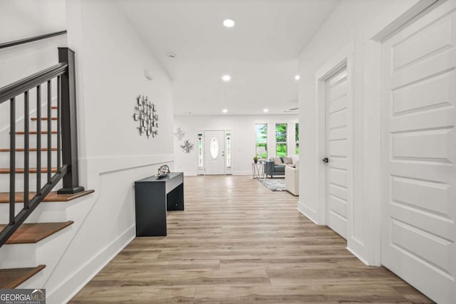 corridor featuring stairs, recessed lighting, baseboards, and wood finished floors