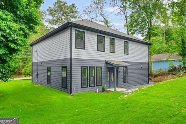 rear view of house featuring a yard