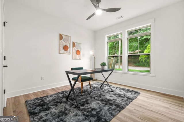 office space with visible vents, baseboards, ceiling fan, and wood finished floors