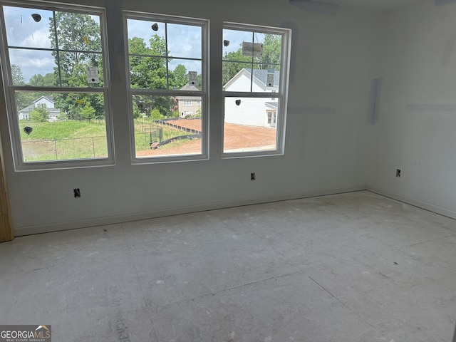 unfurnished room featuring baseboards and a healthy amount of sunlight