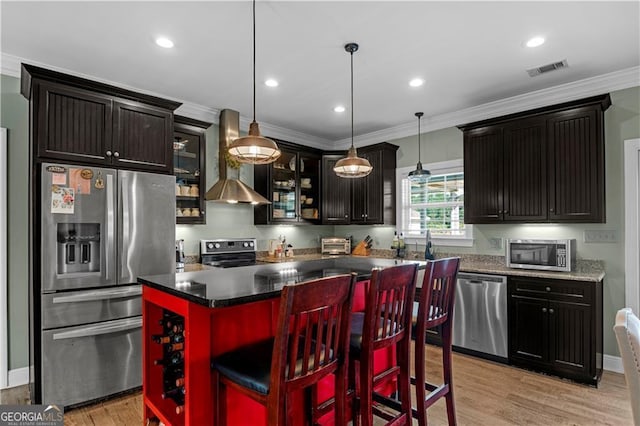 3224 Ware St, Blackshear, GA 31516 - kitchen with wall chimney range hood, appliances with stainless steel finishes, light wood-type flooring, visible vents, and glass insert cabinets