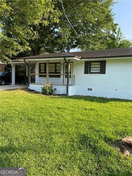 304 Elizabeth Ln, Griffin, GA 30223 - single story home with a porch, a front yard, and a carport