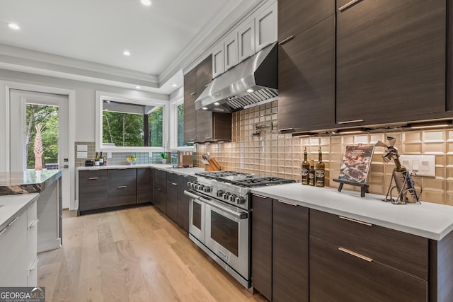 kitchen with ventilation hood, light wood finished floors, dark brown cabinetry, and double oven range