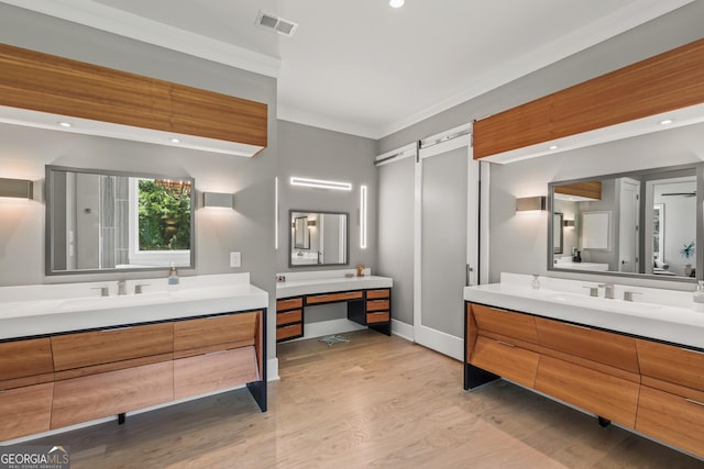 full bathroom with a sink, baseboards, wood finished floors, and two vanities
