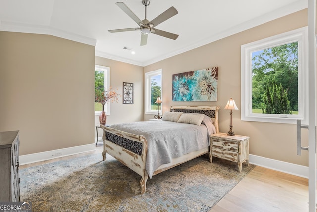 bedroom with baseboards, ornamental molding, wood finished floors, and visible vents