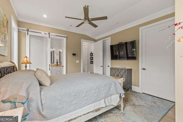 bedroom featuring crown molding, wood finished floors, recessed lighting, a barn door, and connected bathroom