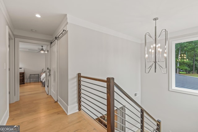 hallway featuring ornamental molding, light wood-type flooring, recessed lighting, a notable chandelier, and an upstairs landing