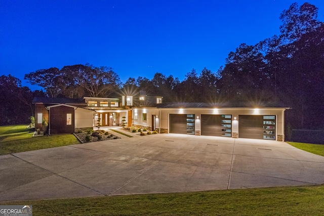 view of front facade featuring an attached garage, stone siding, and concrete driveway