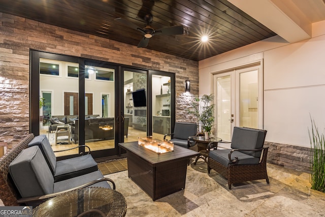 view of patio / terrace featuring a ceiling fan and an outdoor living space with a fire pit