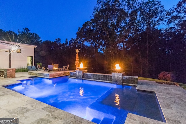 outdoor pool featuring an outdoor fire pit and a patio area