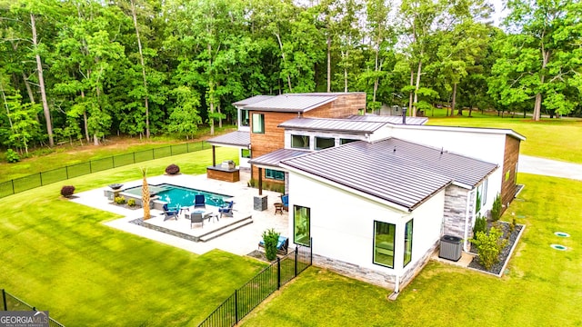 rear view of house with a fenced backyard, stucco siding, a standing seam roof, metal roof, and central air condition unit