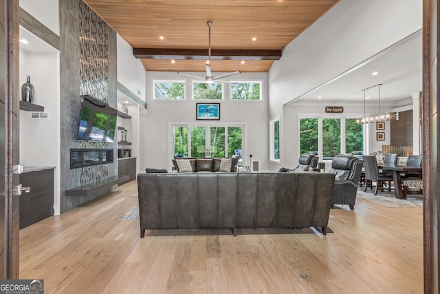 living room featuring light wood-style floors, ceiling fan, a fireplace, and wooden ceiling