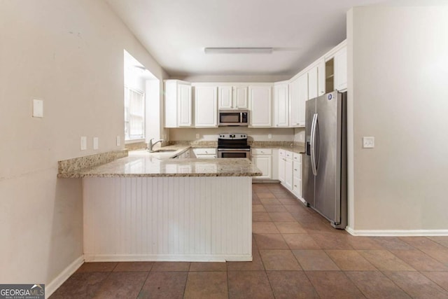 6416 Vicksburg Ct NW, Acworth, GA 30101 - kitchen featuring appliances with stainless steel finishes, a sink, a peninsula, white cabinets, and light stone countertops