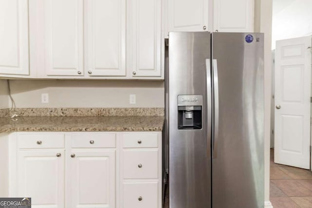 6416 Vicksburg Ct NW, Acworth, GA 30101 - kitchen with stainless steel fridge with ice dispenser, white cabinets, light tile patterned floors, and light stone counters