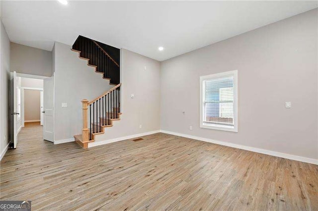 962 Welch St SW, Atlanta, GA 30310 - unfurnished living room featuring light wood-style floors, baseboards, recessed lighting, and stairs