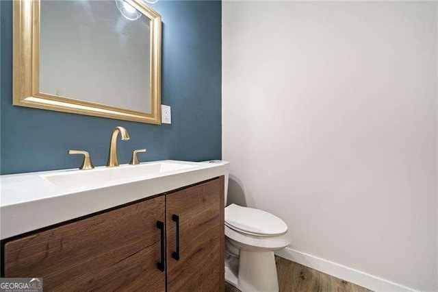 962 Welch St SW, Atlanta, GA 30310 - half bathroom featuring baseboards, vanity, toilet, and wood finished floors