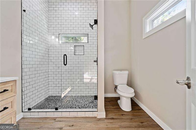 962 Welch St SW, Atlanta, GA 30310 - full bathroom with vanity, wood finished floors, toilet, baseboards, and a shower stall
