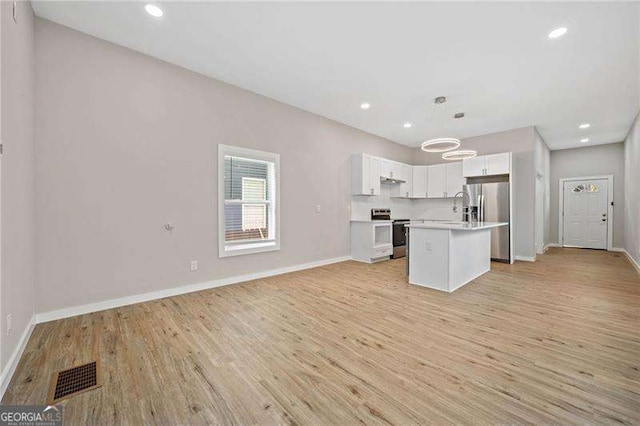 962 Welch St SW, Atlanta, GA 30310 - kitchen with light wood-style floors, visible vents, electric range oven, light countertops, and stainless steel fridge